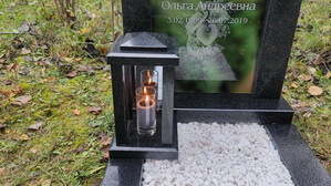Лампада из гранита перед стеклянным памятником с засженной свечой